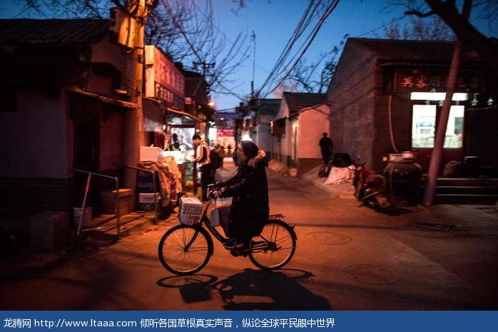 A woman rides her bicycle in a hutong in Beijing. The narrow alleyways are Beijing's traditional form of residence which is thought to have first appeared in the Yuan Dynasty (1271-1368)