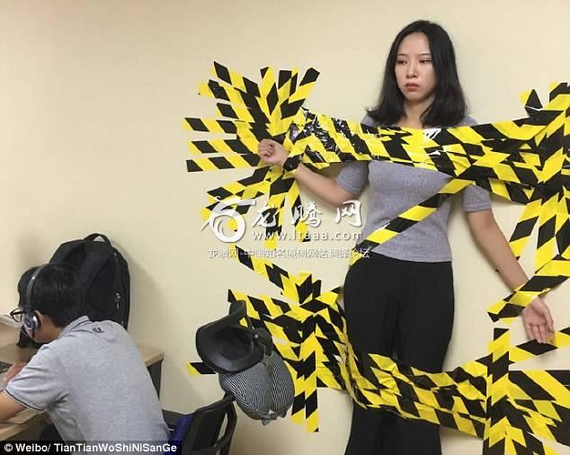 A female worker was taped to the wall in her office as a web user posted on Weibo today