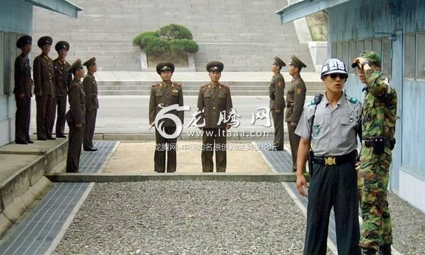 North Korean soldiers stand guard as South Korean soldiers chat in the DMZ. 