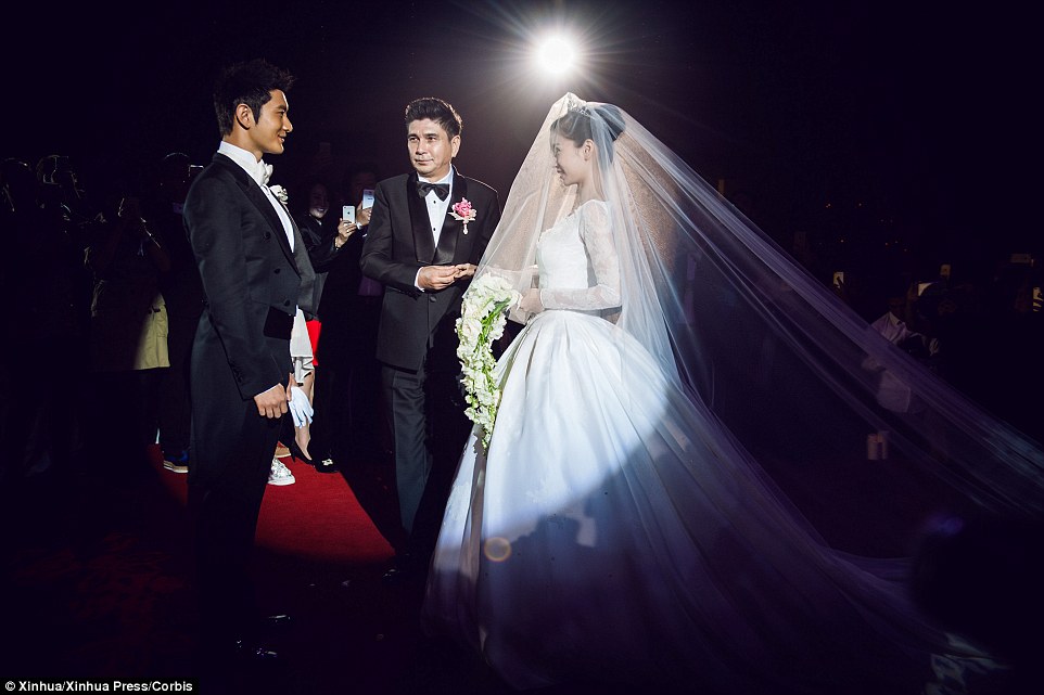 Big day: Shanghai Exhibition Center was filled with thousands of roses and images of the couple were beamed around their venue