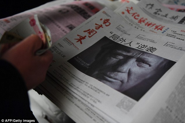 A man buys a Chinese newspaper in Beijing on November 10 with a picture of Donald Trump on the cover