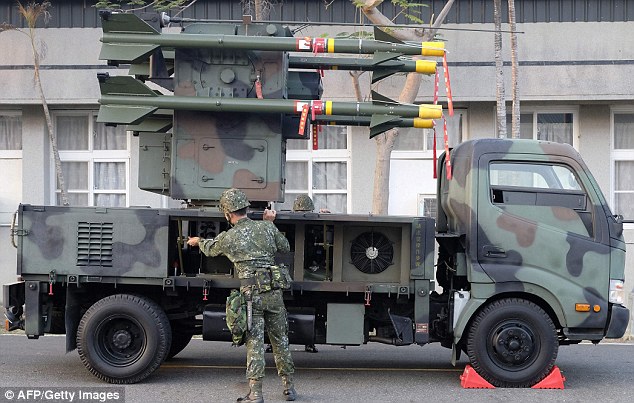 Soldiers held positions next to a US-made Avenger air defence missile system during the drill in central Taichung city as special forces moved in formation through woods and a tank set off smoke bombs and crushed a car