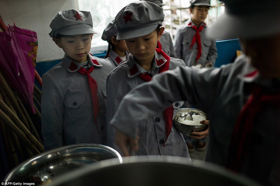 At lunch they line up in the canteen to serve themselves one by one from trays of rice and huge silver pots filled with potatoes beans and chicken