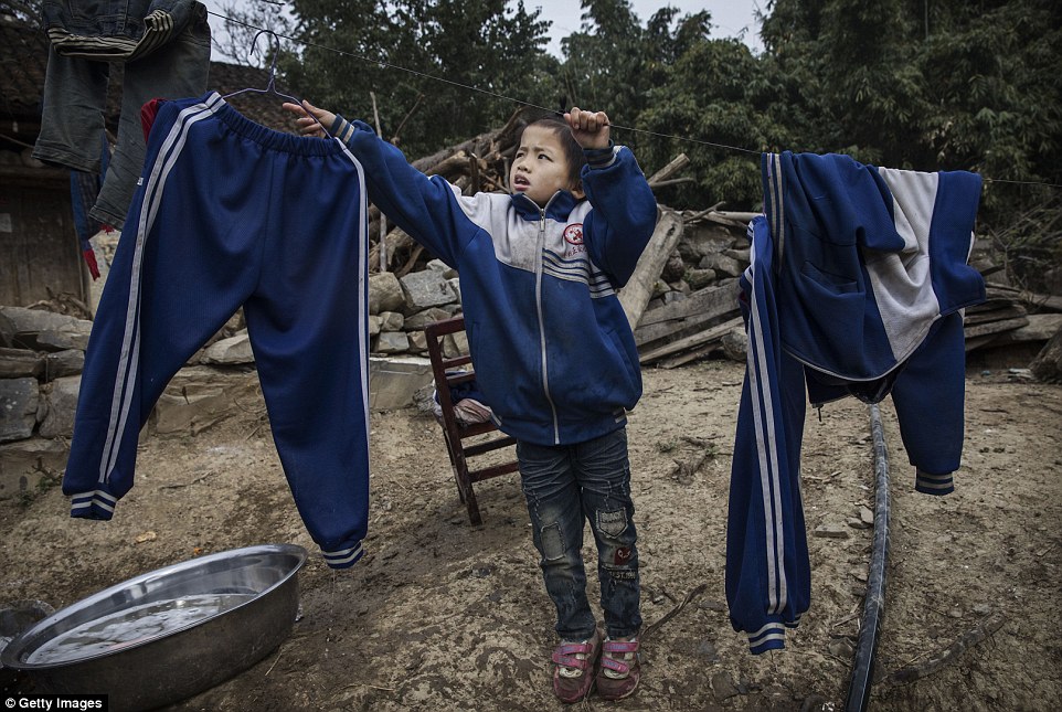 'Left behind' child Luo Hongniu eight hangs laundry after washing clothes with her siblings