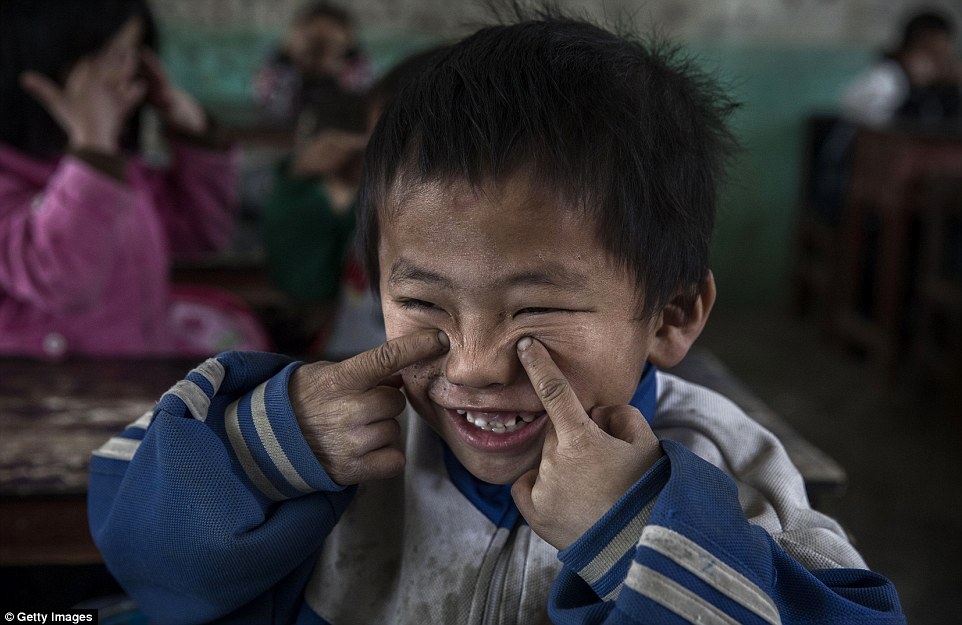 Luo Lie aged five does eye exercises with classmates  at his local school where more than four out of every 10 are 'left behind' children