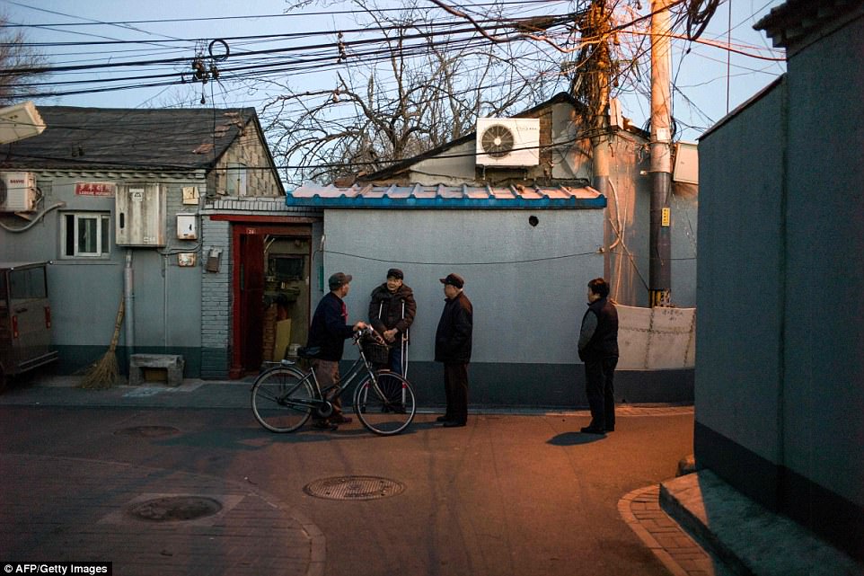 A group of elderly people gathering to talk in Beijing's Luoche Hutong near Beixinqiao subway station. The beauty of the alleys lie in the contrast between fashion and tradition noise and tranquility new trends and old-school gossiping