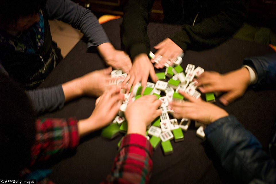 With a large number of people sharing the same space social events are important. Residents are pictured playing mah-jong a traditional Chinese board game in their hutong home