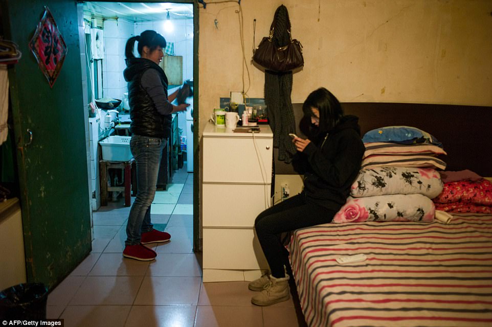 A woman and her daughter are pictured in their home. Younger generations tend to prefer new flats to old cramped hutong but some of them who wish to experience the old-school Beijing lifestyle have begun to move back