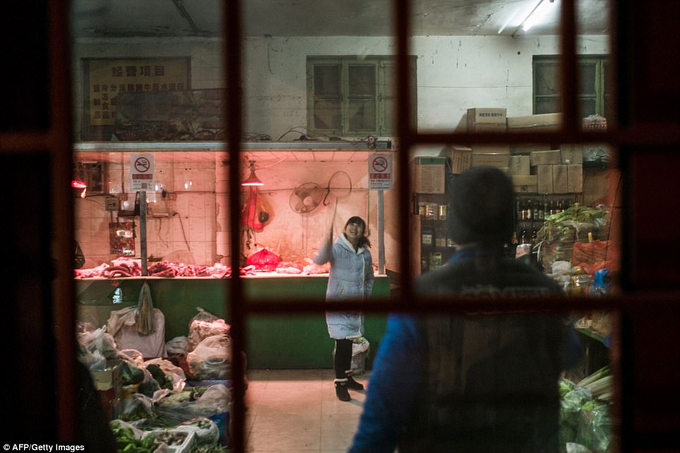 Vendors playing badminton in an indoor farmers' market as they wait for clients. Hundreds of families would live in the same hutong alleyway during China's hard-core Communist era. Nowadays many of these alleyways have been demolished 