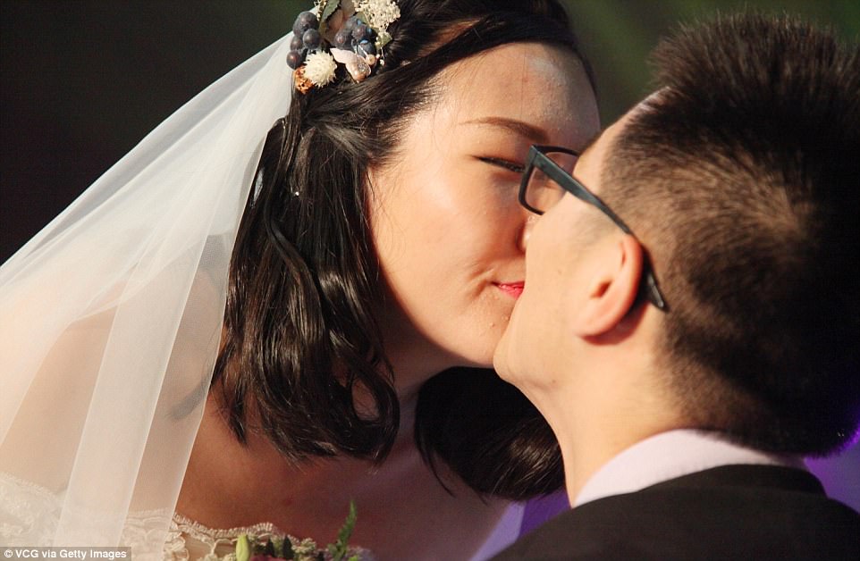 Sealing the deal: A pair of lovebirds at the event. Similar mass weddings have occurred at other universities in China to celebrate anniversaries - such as one at Wuhan last October where the magic number was 123 