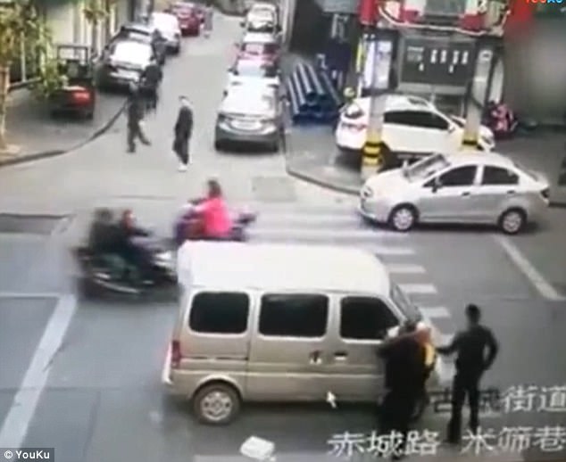 At least two onlookers are trying to stop the car leaving but it dashes off right away