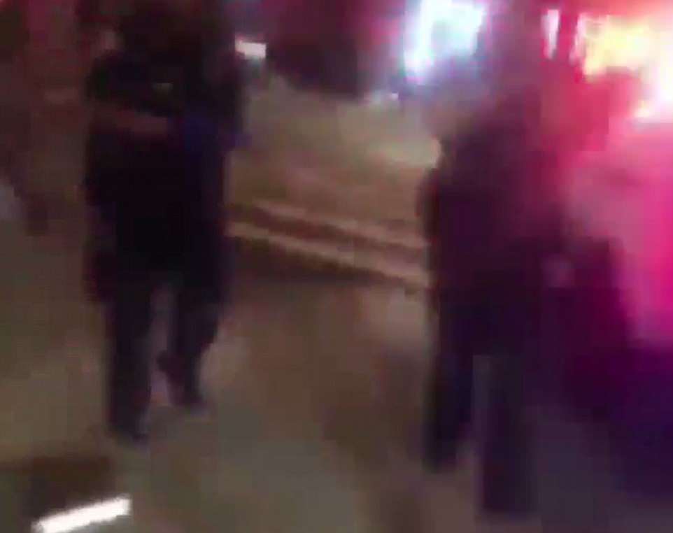 Cellphone video shows 15-year-old murder victim Lesandro 'Junior' Guzman-Feliz lying on the ground as passers-by try to staunch the blood. However two cops (pictured) appear to be watching on rather than doing anything to help